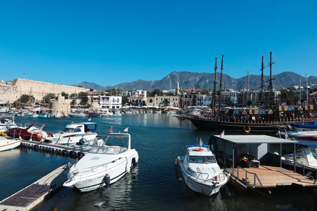 Beautiful boats moored at Kyrenia Harbor with mountains in the background.